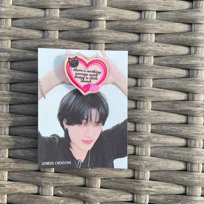 Card with a character holding a heart-shaped object on a woven surface