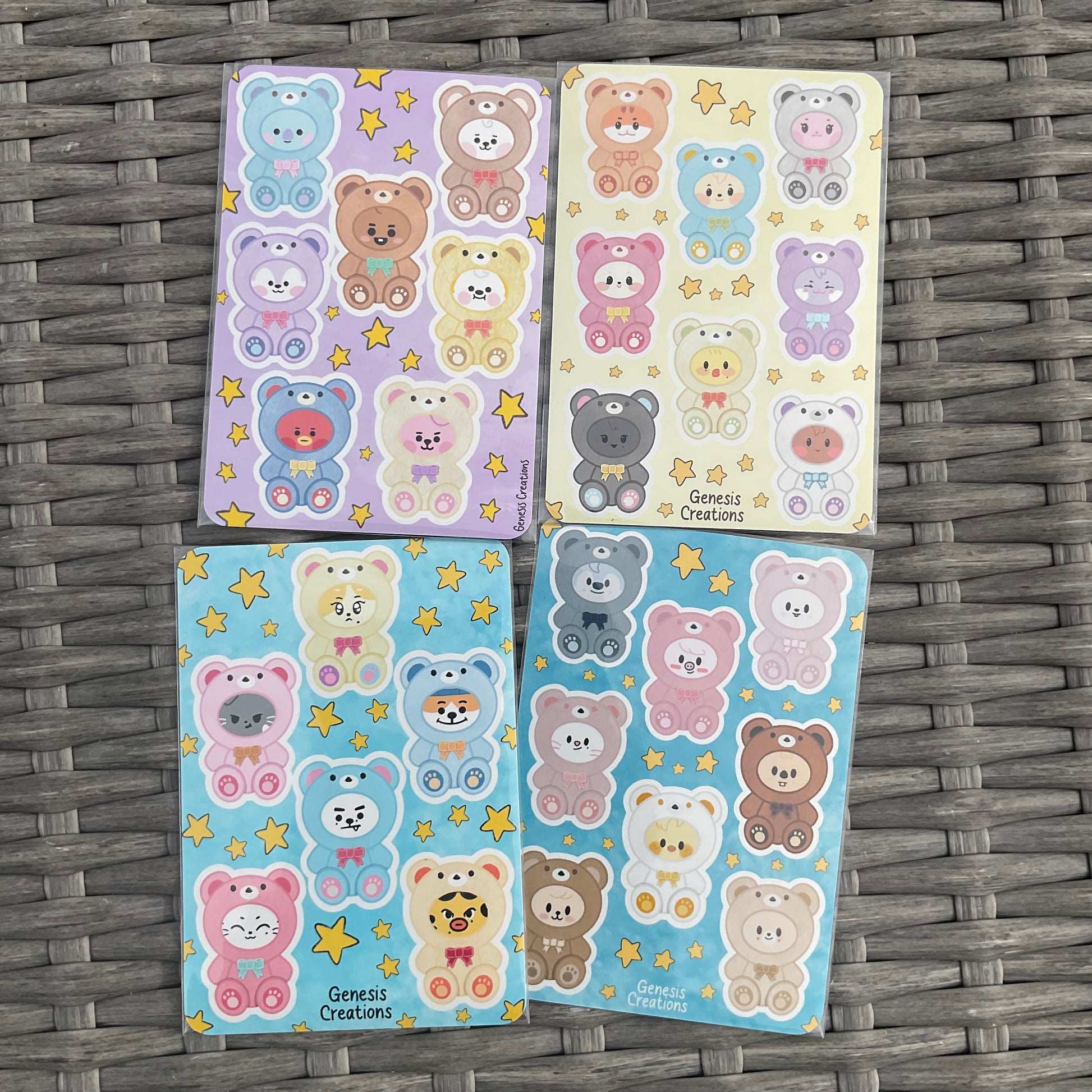 Four sheets of colorful bear-themed stickers on a woven surface