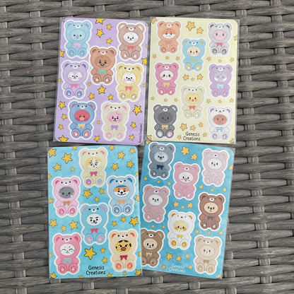 Four sheets of colorful bear-themed stickers on a woven surface