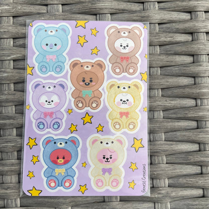 Sheet of colorful bear stickers on a purple background with yellow stars, placed on a woven surface.