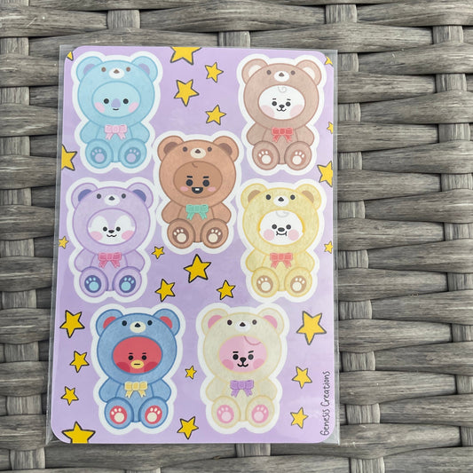Sheet of colorful bear stickers on a purple background with yellow stars, placed on a woven surface.