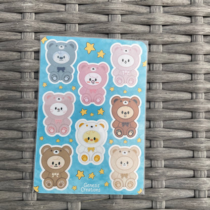 Sheet of bear stickers on a blue background with stars, placed on a woven surface.
