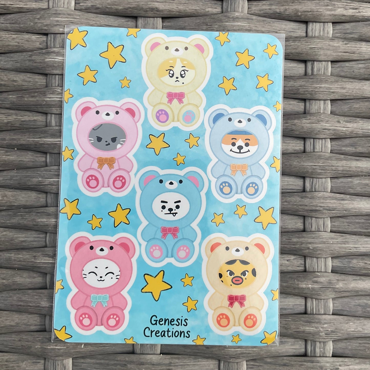 Cartoon bear stickers with stars on a blue background, placed on a woven surface.
