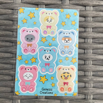 Cartoon bear stickers with stars on a blue background, placed on a woven surface.